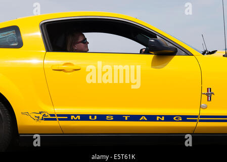 Autofahrerin einen gelben Ford Mustang. Amerikanische Oldtimer Stockfoto