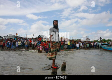 Mawa, Bangladesch, Bangladesh. 4. August 2014. Menschen und Angehörigen steht in der Bank des Flusses Padma. Die Pinak-6, sank ein Passagierschiff mitten im Fluss Padma auf dem Weg zum Mawa aus Kawrakandi terminal. Das Boot kenterte, da der Fluss aufgrund des stürmischen Wetters rau war. Mindestens 250 Menschen waren im gekenterten Boot. Lokale Leute gerettet fast 45 Passagiere vom Fluss und viele andere werden noch vermisst. Stürmisches Wetter und starke Strömung behindern die Rettungsaktion. © Suvra Kanti Das/ZUMA Wire/ZUMAPRESS.com/Alamy Live-Nachrichten Stockfoto