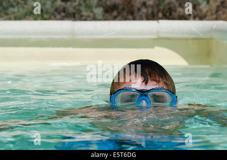 Teenager-Jungen untergetaucht Tauchmaske oder Brille im Schwimmbad tragen. Stockfoto