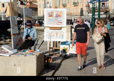 Paar Touristen vorbeigehen Streetart-Künstler auf dem Kai in Saint-Tropez Provence Côte d ' Azur Frankreich Stockfoto