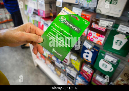 Ein Käufer wählt eine grünen Punkt Marke MoneyPak Prepaid-Karte in einem Store in New York Stockfoto