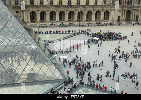 Besucher und Touristen stehen an der Glaspyramide, Eintritt zum Louvre Museum Paris, Frankreich Stockfoto