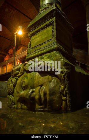 Ein riesiger Kopf der Medusa unterstützt eine Säule in der Basilika-Zisterne in Istanbul, Türkei. Stockfoto
