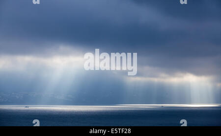 Sonnenlicht geht durch dunkle Wolken. Bucht von Tanger, Marokko Stockfoto