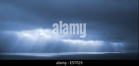 Sonnenlicht geht durch blaue stürmischen Wolken. Bucht von Tanger, Marokko Stockfoto