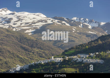 Blick über die Stadt Pampaneira in Richtung der schneebedeckten Berge der Sierra Nevada, Pampaneira, Andalusien, Spanien Stockfoto