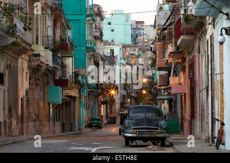 Straßenszene vor Sonnenaufgang mit Gebäuden zusammen und amerikanische Oldtimer, Havanna Centro, Havanna, Kuba, Caribbean Stockfoto