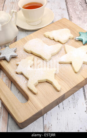 Hausgemachte Weihnachtskekse Shortbread Keks Rentier und festliche Formen mit einer Tasse Tee - vertikale. Stockfoto