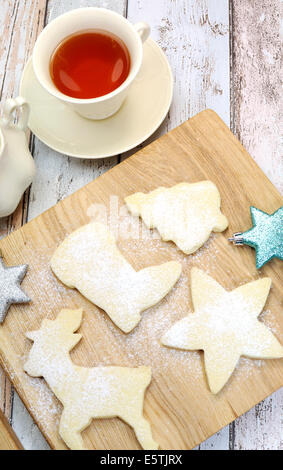 Hausgemachte Weihnachtskekse Shortbread Keks Rentier und festliche Formen mit einer Tasse Tee - vertikale. Stockfoto