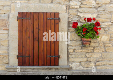 Fenster in einem alten Haus mit Blumentöpfen und Blumen geschmückt Stockfoto