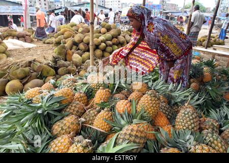 August 2014. Eine Frau aus Bangladesch Früchte Anbieter schält sie Ananas in einem lokalen Obstmarkt im Old Dhaka. Stockfoto