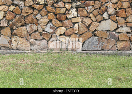 Braune Steinmauer und grünen Rasen für den Hintergrund. Stockfoto