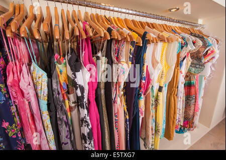 Vielzahl von bunten Sommer Damenmode hängen auf der Schiene im Modegeschäft Stockfoto