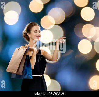 lächelnde Frau in Tracht mit Einkaufstüten Stockfoto