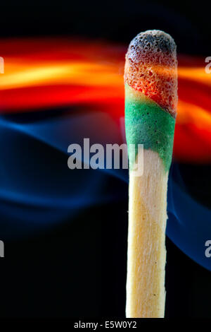 Brennen mit blauen Rauch über schwarzem Hintergrund Stockfoto