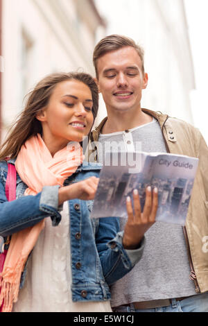 lächelnde paar mit Stadtführer, die Stadt zu erkunden Stockfoto