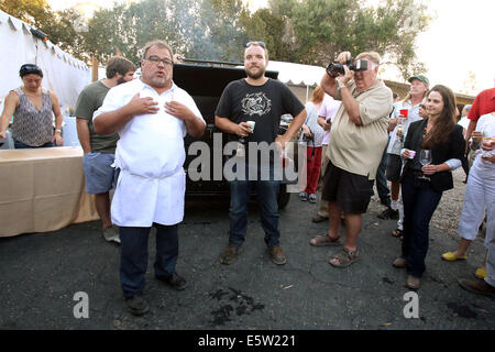 Santa Barbara County, Kalifornien, USA. 1. August 2014. NICK PIHAKIS von Jim 'N Nicks Bar-B-Q, Mitte links, und RYAN PHARR, Mitte rechts, sprechen von 4505 Fleisch in San Francisco vor dem Winzer Mittagessen in der Feier des 10. Jahrestages des Films '' seitlich '' bei Rancho la Cuna am 1. August 2014 in Santa Barbara County, Kalifornien. Eine ganzes Schwein, JNN Fischfarmen, wurde eingeflogen, Bbqed für das Abendessen aus Alabama von Nick Pihakis und Nicolas Pihakis von Jim 'N Nicks Bar-B-Q. Es ist Tradition, dass die Gäste ein Bourbon-Schuss zu tun, da das Schwein vor dem Abendessen kocht. (Kredit-Bild: © Krista Kennell/ZUMA Stockfoto