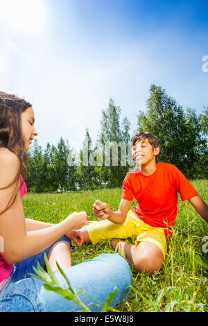 Kinder spielen auf dem Rasen, Stein-Schere-Papier Stockfoto