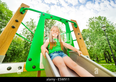 Lachende Mädchen auf Kinder Rutsche bereit zu schieben Stockfoto