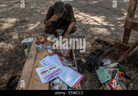 Süd-Israel, Israel grenzt an den Gaza-Streifen. 6. August 2014. Ein israelischer Soldat packt Essen und Notwendigkeiten mit einer Sammlung von Gemälden von Kindergartenkindern von zentralen israelischen Stadt Natanya, im Süden Israels im Gaza-Streifen am 6. August 2014 an der Grenze geschickt. Israel hat beschlossen, die laufenden Waffenruhe im Gaza-Streifen mit der palästinensischen Hamas-Bewegung, zu verlängern das ägyptische Staatsfernsehen berichtete spät am Mittwoch. Und eine israelische offizielle fordern Anonymität hat bestätigt, Xinhua, dass beide Seiten geeinigt haben, bedingungslos den aktuellen Waffenstillstand zu verlängern. Bildnachweis: Li Rui/Xinhua/Alamy Live Stockfoto