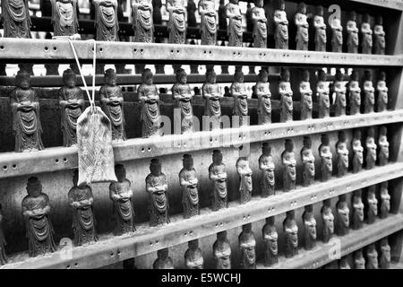 Reihen von Mini Buddha Figuren Linie das innere Heiligtum des Shintō-buddhistischen Tempel in Nagano City, Japan, schwarz-weiß-Bild der religiösen Objekte Stockfoto
