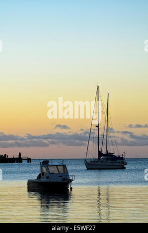 Ruhige Szene - Boote in Ruhe in der Nähe von Sonnenuntergang in einem ruhigen tropischen Hafen. Stockfoto