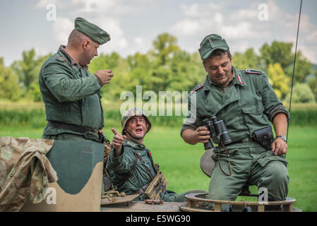 Deutscher Soldat im Gespräch mit Kameraden auf einem Panzer während der Nachstellung des zweiten Weltkriegs Kampf Stockfoto