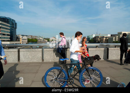 Mann über London Brücke im Sonnenschein im Sommer zu Fuß, schob ein blaues Fahrrad London UK KATHY DEWITT Stockfoto