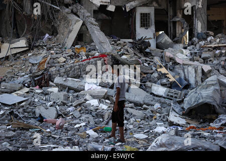 Gaza. 7. August 2014. Palästinensischen Jungen suchen einige Dinge in den zerstörten Häusern in der Stadt Beit Lahiya, wie die fragile 72 Stunden Waffenruhe im Gaza-Streifen seinen dritten Tag eingegeben. Die israelischen und palästinensischen Delegierten vorbereitet für Crunch Gespräche in Kairo versucht, die 72-Stunden Waffenruhe zu erweitern. Bildnachweis: Ahmed Hjazy/Pacific Press/Alamy Live-Nachrichten Stockfoto