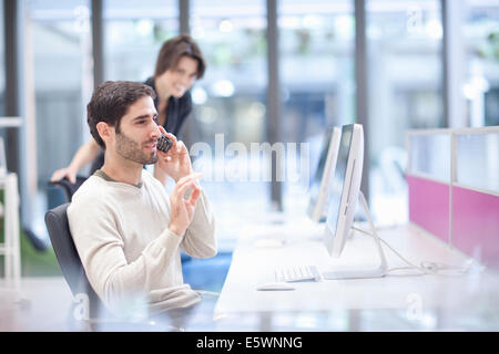 Männlicher Büroangestellter auf Festnetz-Telefon Stockfoto