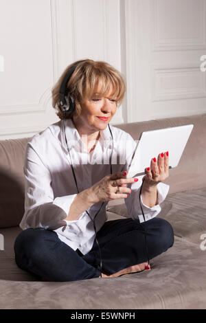 Frau mit digital-Tablette auf sofa Stockfoto