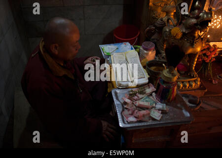 Ein tibetischer Mönch an der tibetischen buddhistischen Stupa von Boudhanath dominiert die Skyline von Kathmandu. Stockfoto