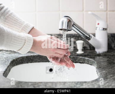 Aufnahme der jungen Frau, die Hände im Waschbecken zu waschen beschnitten Stockfoto