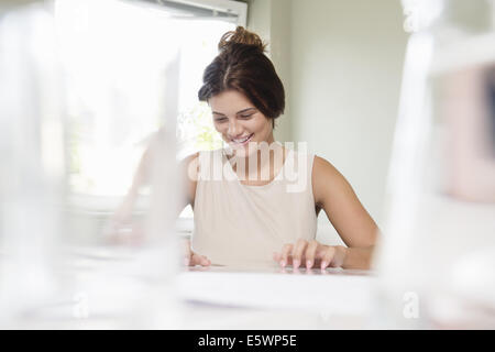 Junge Geschäftsfrau Blick auf Schreibarbeit im Sitzungssaal Stockfoto