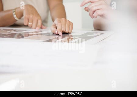 Aufnahme von zwei Geschäftsfrauen Hände und Blaupause abgeschnitten Stockfoto