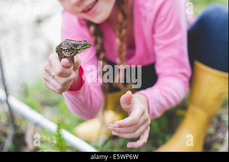 Schuss von Mädchen hält Frosch beschnitten Stockfoto