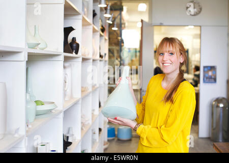 Frau mit Keramikvase in Werkstatt Stockfoto