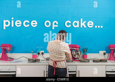 Rückansicht des jungen Frau mit Mixer in Bäckerei Stockfoto