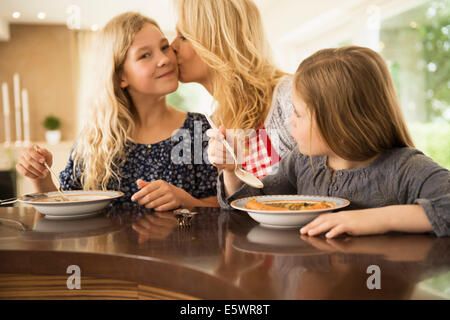 Mutter küssen Tochter auf Wange Stockfoto