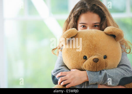 Porträt des jungen Mädchens umarmt Teddybär Stockfoto