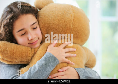 Porträt des jungen Mädchens umarmt Teddybär Stockfoto