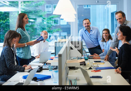 Unternehmer treffen um Schreibtisch Stockfoto