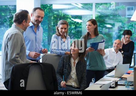 Unternehmer treffen um Schreibtisch Stockfoto