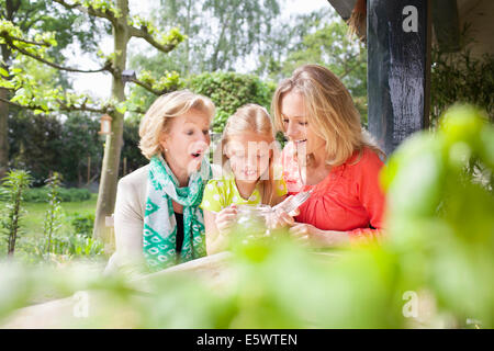 Mädchen Eröffnung Glas von Münzen mit Familie Stockfoto