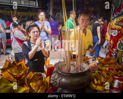 Bangkok, Bangkok, Thailand. 7. August 2014. Die Menschen beten auf einem Altar Pek Leng Keng Mangkorn Khiew Schrein. Tausende von Menschen, die für die Verteilung von Nahrungsmitteln an die Pek Leng Keng Mangkorn Khiew Schrein im Abschnitt Khlong Toei, Bangkok Donnerstag aufgereiht. Khlong Toei ist eines der ärmsten Schichten von Bangkok. Der siebte Monat des chinesischen Mondkalenders nennt man '' Ghost Monat '' während die Geister und Gespenster, einschließlich derjenigen der verstorbenen Vorfahren aus dem unteren Bereich kommen. Bildnachweis: ZUMA Press, Inc./Alamy Live-Nachrichten Stockfoto