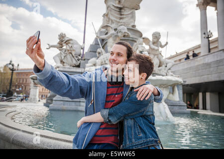 Junge Erwachsene paar unter Bild von sich selbst, Wien, Österreich Stockfoto