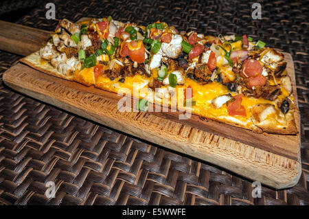 Frischem Ciabatta-Brot-Pizza mit frischem Gemüse, Wurst und Käse, serviert auf einem Holz Schneidebrett erstickt. Stockfoto