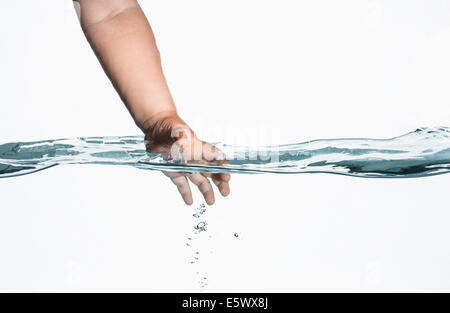 Ebene Oberflächenansicht Kleinkinder Hand Hineingreifen in klarem Wasser Stockfoto