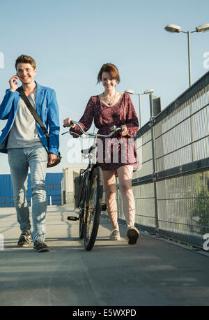 Junges Paar Brücke Fahrrad umstoßen Stockfoto