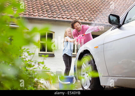 Mädchen half Vater sein Auto waschen Stockfoto